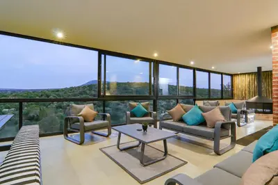 a living room with couches and a table at Cliffhanger Lodge in Mabula
