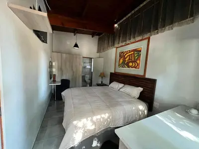 a bedroom with a bed and a desk in it at Two Firs Irene in Centurion
