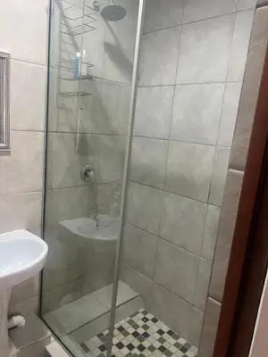 a shower with a glass door next to a sink at Two Firs Irene in Centurion