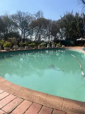 a large swimming pool with a water hose at Two Firs Irene in Centurion