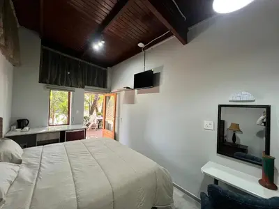 a bedroom with a large bed and a mirror at Two Firs Irene in Centurion