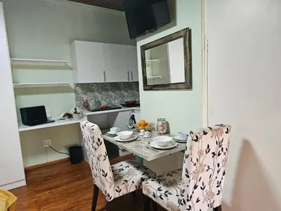 a kitchen with a table with two chairs and a mirror at King Sanctuary in Centurion