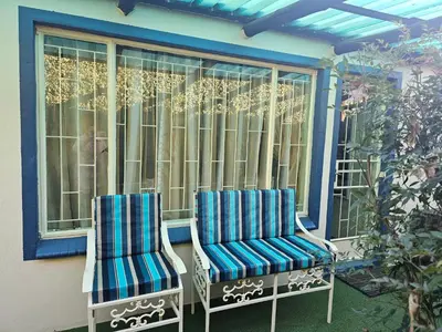 two chairs sitting on a porch next to a window at King Sanctuary in Centurion