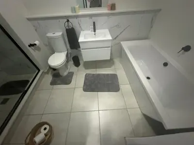 a bathroom with a toilet and a tub and a sink at The Blyde Lagoon Apartment in Pretoria