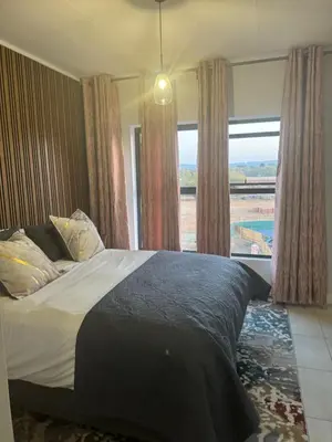 a bedroom with a bed and a large window at The Blyde Lagoon Apartment in Pretoria