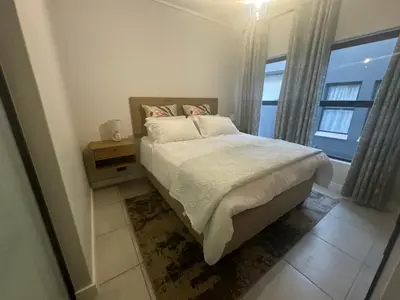 a bedroom with a bed and a window at The Blyde Lagoon Apartment in Pretoria