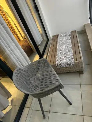a chair and a bed in a room at The Blyde Lagoon Apartment in Pretoria