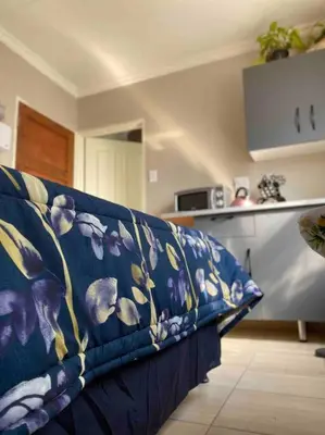 a blue couch sitting in a living room at SummerPlace - Studio Apartment with Kitchenette in Modimolle