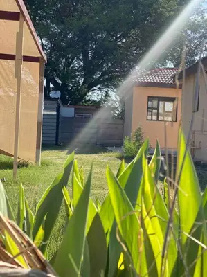a house with a sprinkler in front of a house at SummerPlace - Studio Apartment with Kitchenette in Modimolle