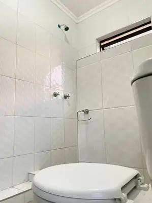 a white bathroom with a toilet and a shower at SummerPlace - Studio Apartment with Kitchenette in Modimolle