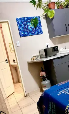 a room with a bed and a microwave on a counter at SummerPlace - Studio Apartment with Kitchenette in Modimolle