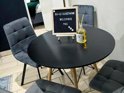 a black dining room table with a bottle of wine on it at SuLo Guesthome in Phalaborwa