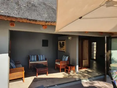 a patio with chairs and a table and a building at Mokaikai - The Soaring Eagle in Mabula