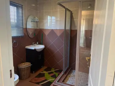 a bathroom with a shower and a sink at Pringle Studio in Benoni
