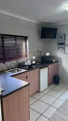 a kitchen with a sink and a refrigerator at Lumis Rest in Tzaneen