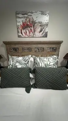 a bed with two pillows and a painting on the wall at Lumis Rest in Tzaneen