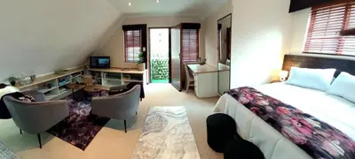 a bedroom with a bed and a desk and a table at Rose Loft in Centurion