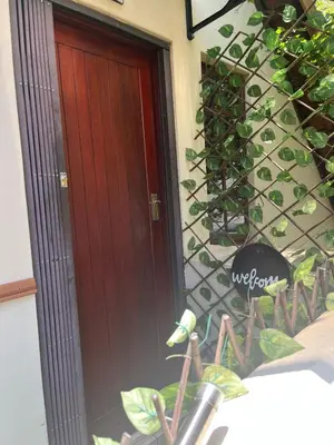 a red door of a house with a plant at Rose Loft in Centurion