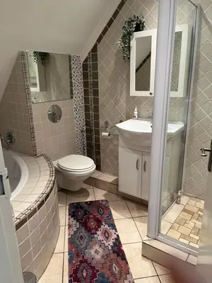a bathroom with a toilet and a sink and a shower at Rose Loft in Centurion