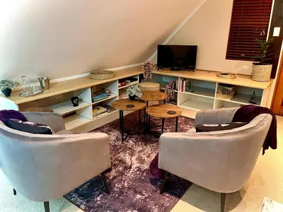 a living room with two chairs and a television at Rose Loft in Centurion