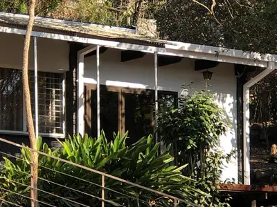 a white house with a front door and some plants at Esibayeni Guesthouse in Nelspruit