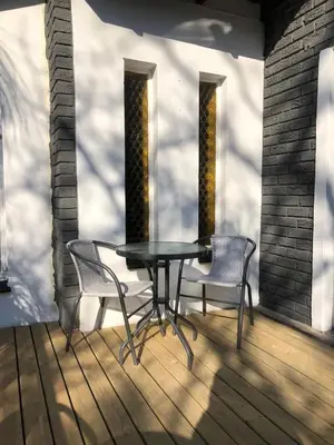 a table and two chairs on a wooden deck at Esibayeni Guesthouse in Nelspruit