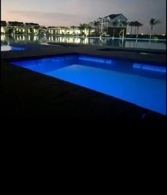 a large swimming pool with blue water at night at 521 at The Blyde in Pretoria