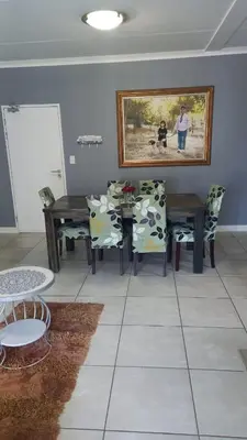 a dining room with a table and chairs and a picture on the wall at 521 at The Blyde in Pretoria