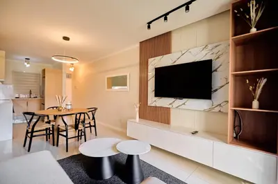 a living room with a television on a wall at The Dream, Unit N105 at Glen Park in Pretoria