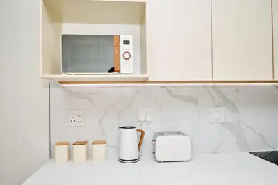 a white kitchen with a toaster and a microwave at The Dream, Unit N105 at Glen Park in Pretoria