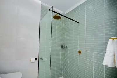 a bathroom with a shower with blue tile at The Dream, Unit N105 at Glen Park in Pretoria