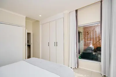 a bedroom with a bed and a large window at The Dream, Unit N105 at Glen Park in Pretoria