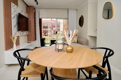 a dining room with a wooden table and chairs at The Dream, Unit N105 at Glen Park in Pretoria