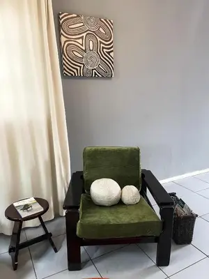 a green chair with two pillows in a room at Serenity in the city - one bedroom apartment in Pretoria