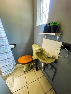 a bathroom with a yellow toilet and a sink at Serenity in the city - one bedroom apartment in Pretoria