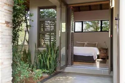 a guest house with a bedroom with a bed and windows at Mokaikai - The Great Buffalo in Mabula