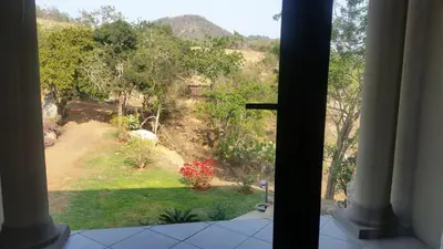 a view of a garden from a window at Jackal Buzzard Mountain Haven in Hillsowen