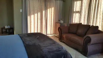 a living room with a couch and a chair at Jackal Buzzard Mountain Haven in Hillsowen