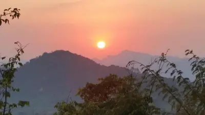 a sunset over a mountain range with the sun setting at Jackal Buzzard Mountain Haven in Hillsowen