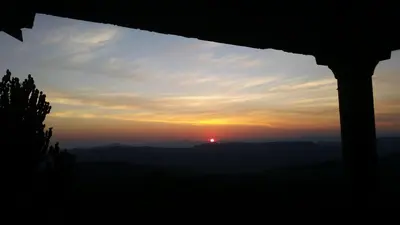 a sunset seen through a window of a building at Jackal Buzzard Mountain Haven in Hillsowen