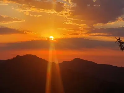 a sunset over the mountains with the sun shining at Jackal Buzzard Mountain Haven in Hillsowen