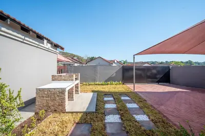 a garden with a stone bench in a backyard at Golden Utopia in Nelspruit