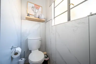a small bathroom with a toilet and a window at Golden Utopia in Nelspruit
