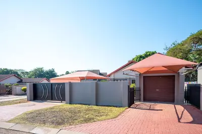 a house with a garage with an umbrella at Golden Utopia in Nelspruit