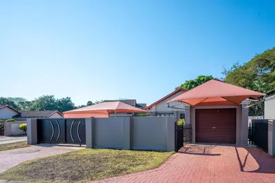 a house with a garage with an umbrella at Golden Utopia in Nelspruit
