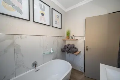 a bathroom with a white tub and a toilet at Golden Utopia in Nelspruit