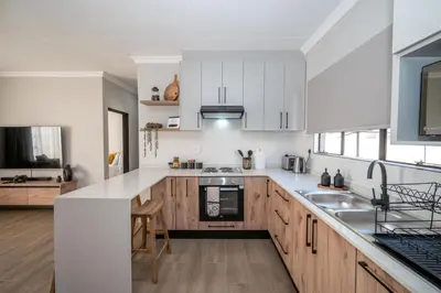 a kitchen with white appliances and wooden cabinets at Golden Utopia in Nelspruit