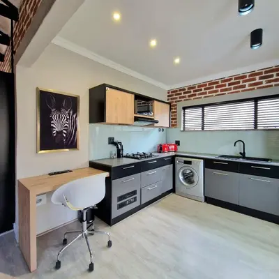 a kitchen with a white chair in a room at Menlyn View Unit 8 in Pretoria