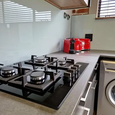 a kitchen with a stove top with a red appliance at Menlyn View Unit 8 in Pretoria