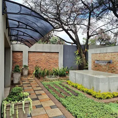 a garden with a large umbrella in a courtyard at Menlyn View Unit 8 in Pretoria